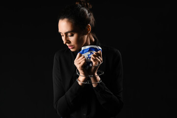 Young woman with flag of Israel and barbed wire praying on black background. International...