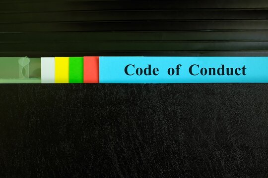 Code of conduct file record in black binder folder. Company code of conduct ethical standard concept.