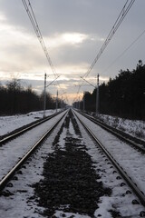 Iron rails of a railway near a train station of a railroad in winter with snow in Europe
