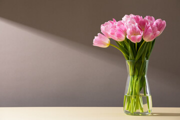 Pink tulips in a vase on a table