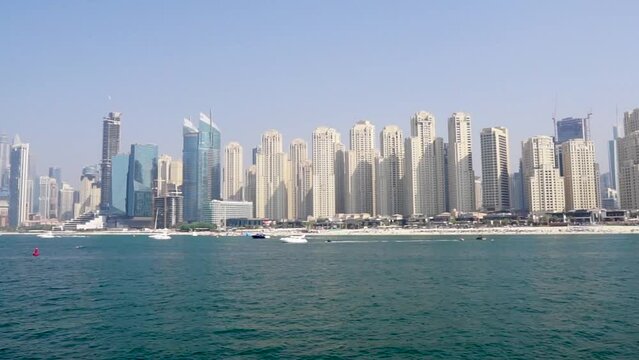 Boats on the beach in Dubai with skyscrapers in the background