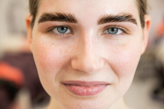 Close-up portrait of a woman after the procedure of correction and lamination of eyebrows. 