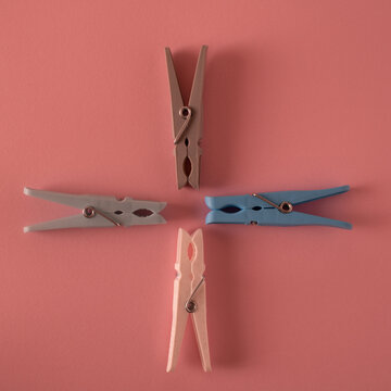 United As A Whole, The Different Are Much Stronger. Together They Have Power. Clothespins In Different Colors Of White, Blue, Brown And Gray Form An Abstract Whole On A Pink Background