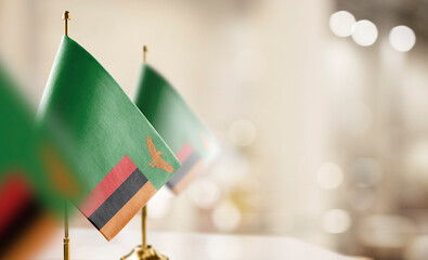 Small flags of the Zambia on an abstract blurry background