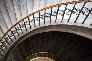 Obraz premium Curved stairs with marble steps and steel railing , pink wall background at the the luxury hall.