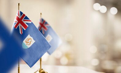 Small flags of the Anguilla on an abstract blurry background