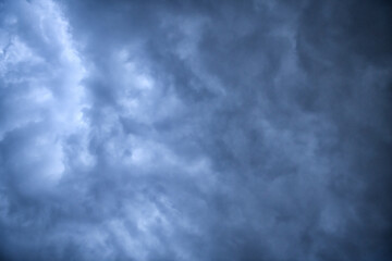 Storm clouds floating in a rainy day with natural light. Cloudscape scenery, overcast weather above blue sky. White and grey clouds scenic nature environment background