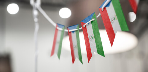 A garland of Equatorial Guinea national flags on an abstract blurred background