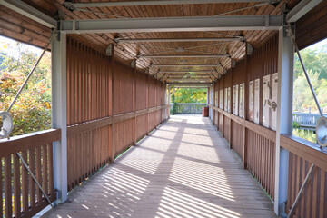 Elevated pedestrian bridge wooden with railings in city park outdoor no people
