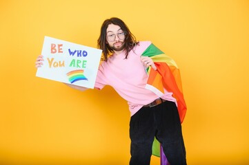 Hands of gay man holding lgbt banner on rainbow flag background lgbt symbol
