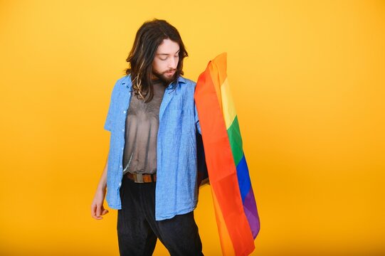 Young Gay Man Is Standing In The Studio And Posing For A Camera.