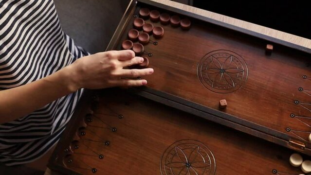 Girl playing backgammon at the table