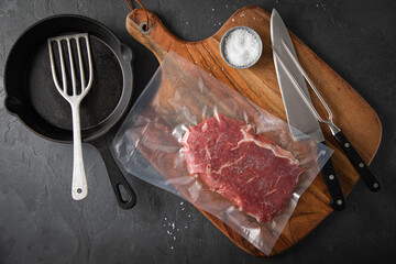 Entrecote Steak roh vakuumiert vom Rind mit Meersalz auf Teller bei Vorbereitung in Küche mit...