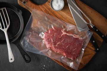 Entrecote Steak roh vakuumiert vom Rind mit Meersalz auf Teller bei Vorbereitung in Küche mit...