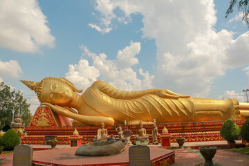 Fototapeta premium Wallpaper of Vientiane the golden city with sleeping buddha statue and golden temple. Popular for the giant gate. Asia