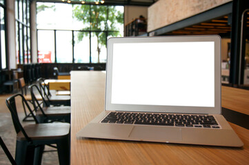 Laptop with Mock up blank screen on wooden table in front of cafe space for text. product display computer laptop montage- technology Freelance work concept
