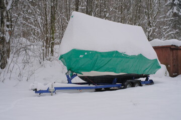 Yacht, boat, ship on the shore under a canopy awning in the snow
