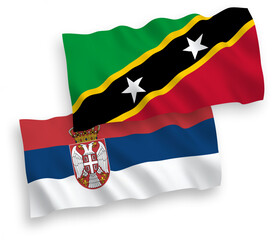 National vector fabric wave flags of Federation of Saint Christopher and Nevis and Serbia isolated on white background. 1 to 2 proportion.