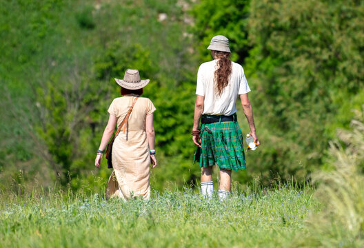 A man in an Irish skirt walks with a girl