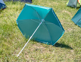 An open umbrella lies on the grass