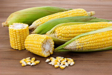 Fresh corn on cobs on wooden table