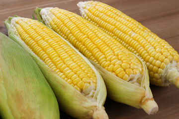close up Fresh corn on cobs on wooden table