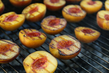 Modern grill with tasty cut peaches, closeup