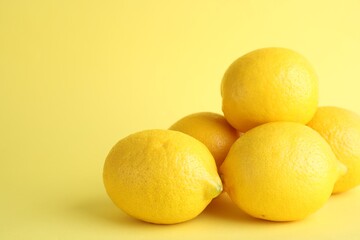 Fresh ripe lemons on yellow background. Space for text