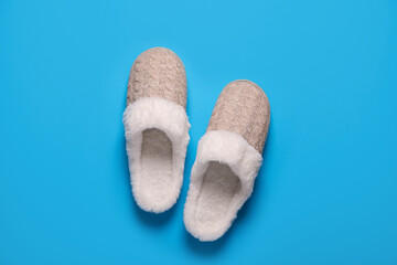 Pair of beautiful soft slippers on light blue background, top view