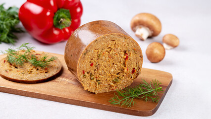 Mushroom based vegan sausage with vegetables and spices on wooden board, top view