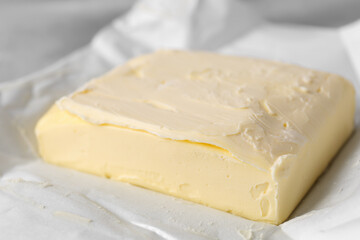 Piece of tasty homemade butter on paper wrap, closeup