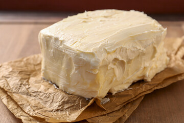 Parchment with tasty homemade butter on wooden table