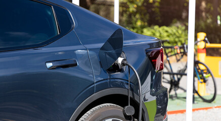 Fototapeta premium EV car Charger for electric with low battery charging at electric charge station..