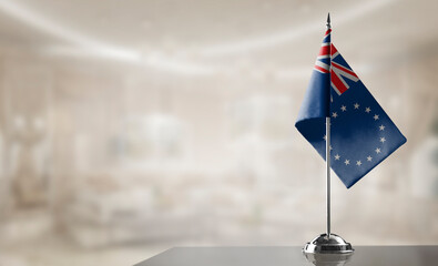 Fototapeta premium A small Cook Islands flag on an abstract blurry background