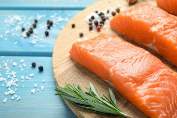 Fresh raw salmon and ingredients for marinade on light blue wooden table, closeup. Space for text