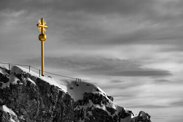 Golden summit cross on top of the “Zugspitze“ (2962 m above sea level), highest peak of Germany...