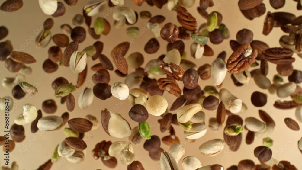 Poster super slow motion of rotating mix nuts up to the air. filmed on high speed cinema camera, 1000fps, p