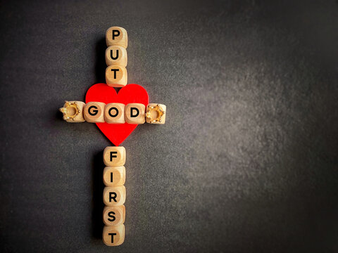 Religion Concept - put God first text on wooden cubes with cross shaped background.Stock photo.