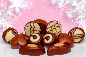Chocolate candy collection. Beautiful assortment of expensive Swiss chocolate truffles and praline sweets on table over abstract festive background. Copy space.