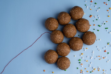 Happy Sankranti, Sankranti greeting card, indian festival with tilgul laddu or laddoo as kite on blue background depicting sky, Makar Sankranti festival in hindu religion in India, indian sweet laddu