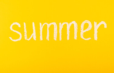 The inscription in chalk SUMMER on a bright yellow background. summer vacation.