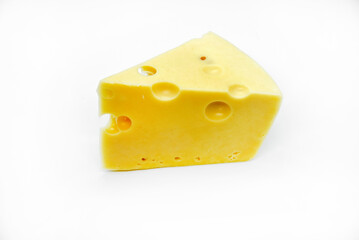 A large piece of cheese on a white background. A triangular piece of cheese with holes.