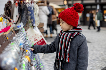Child in Prague on Christmas, looking at the store windows with toys