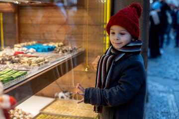 Child in Prague on Christmas, looking at the store windows with toys