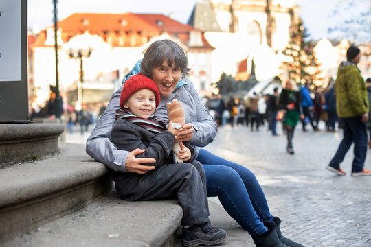 Child in Prague on Christmas, eating traditional czech dessert trdelnik