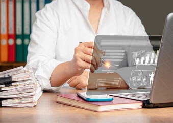Businessman uses a pen to sign electronic document on a virtual screen while sitting at the table