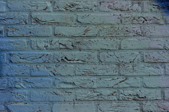 Close-up of light blue graffiti on brick wall