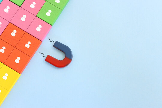 Concept image of a magnet attracting a group of people. metaphor of media influence and human resources