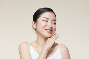 Smiling asian woman touching healthy skin portrait