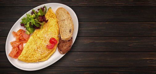 Omelette with salmon, lettuce and toast, on a white plate. breakfast